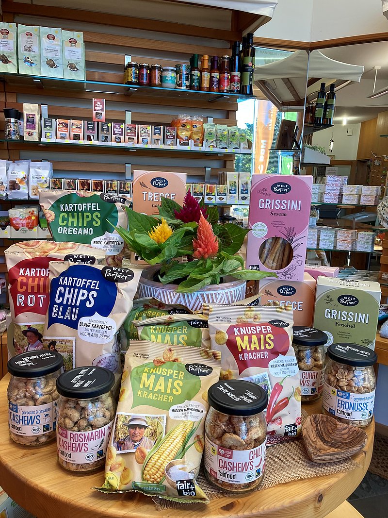 Verschiedenen Snacks, darunter Kartoffelchips, Brotstangen, Nüsse und Maissnacks.